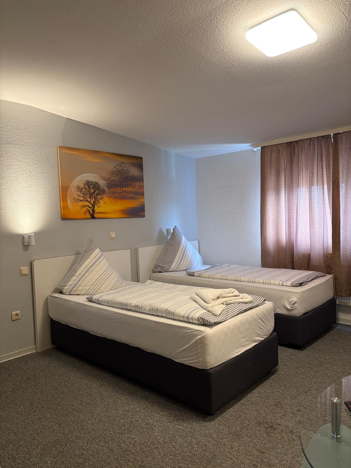 Double room with two single beds and wall mural at Hotel Weller Dietzenbach