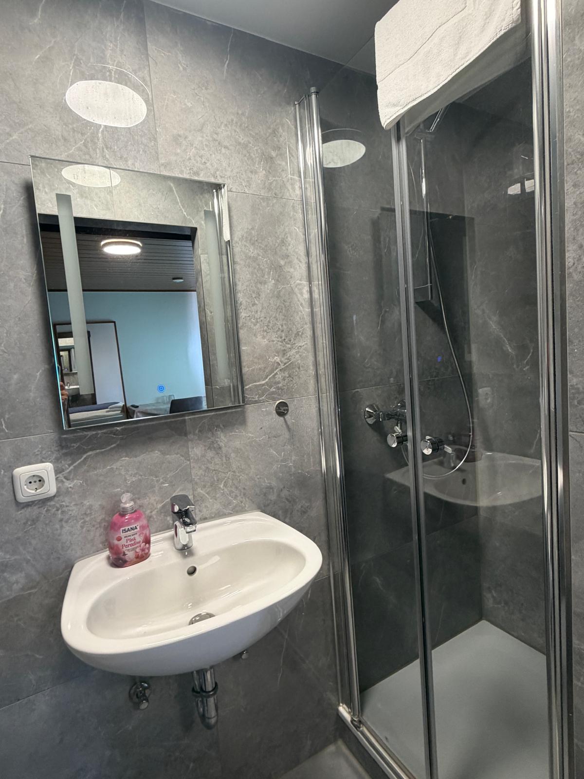 Bathroom with shower cubicle and mirror cabinet at Hotel Weller Dietzenbach