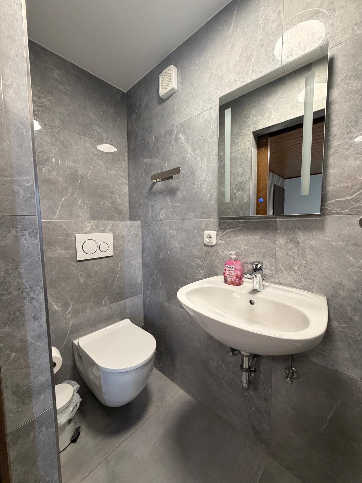 Modern grey bathroom with sink and wall-mounted toilet at Hotel Weller Dietzenbach