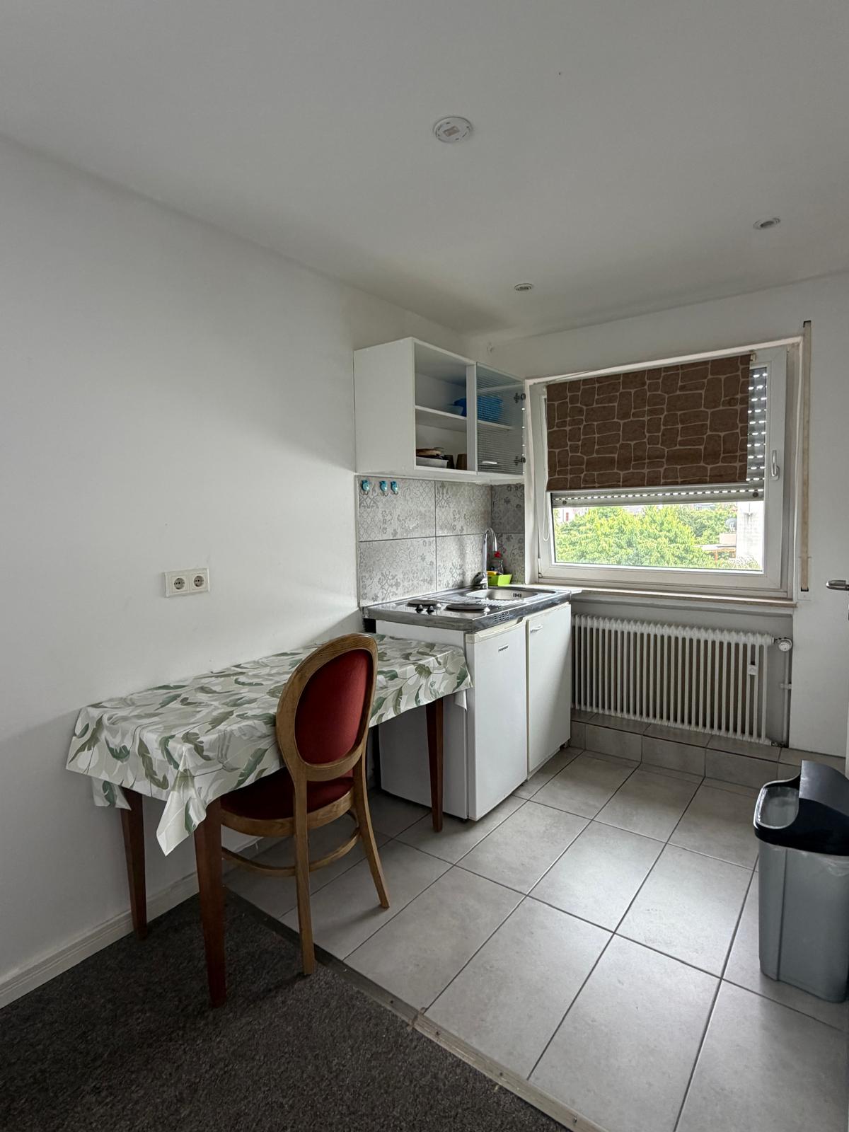 Kitchenette with table by the window in an apartment at Hotel Weller Dietzenbach